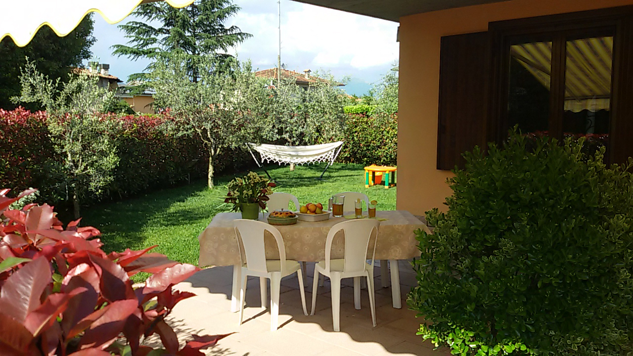Terrazza con tavola imbandita e giardino sullo sfondo